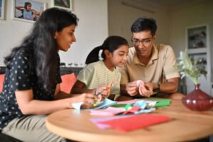 Parents with daughter doing paper craft together